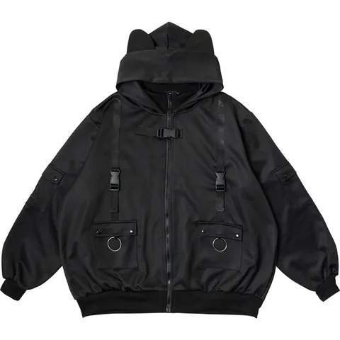 Product photograph: a black hooded jacket with small pointed cat ears on the hood, two large chest pockets with metal rings, and buckled straps, on a white background.