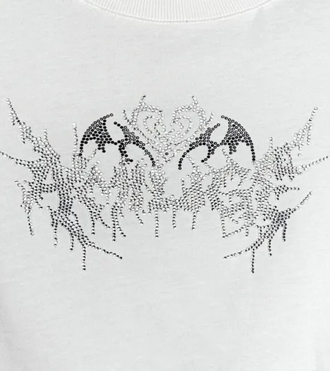 Close view of a rhinestone bat-wing and heart motif set into white jersey.