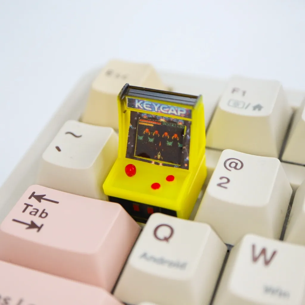 Keycap shaped like a miniature arcade cabinet with a light-up screen