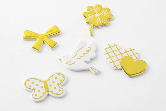 Official MIDORI photo of gold and white clover, bow, dove, butterfly and heart stickers, with raised side edges visible.